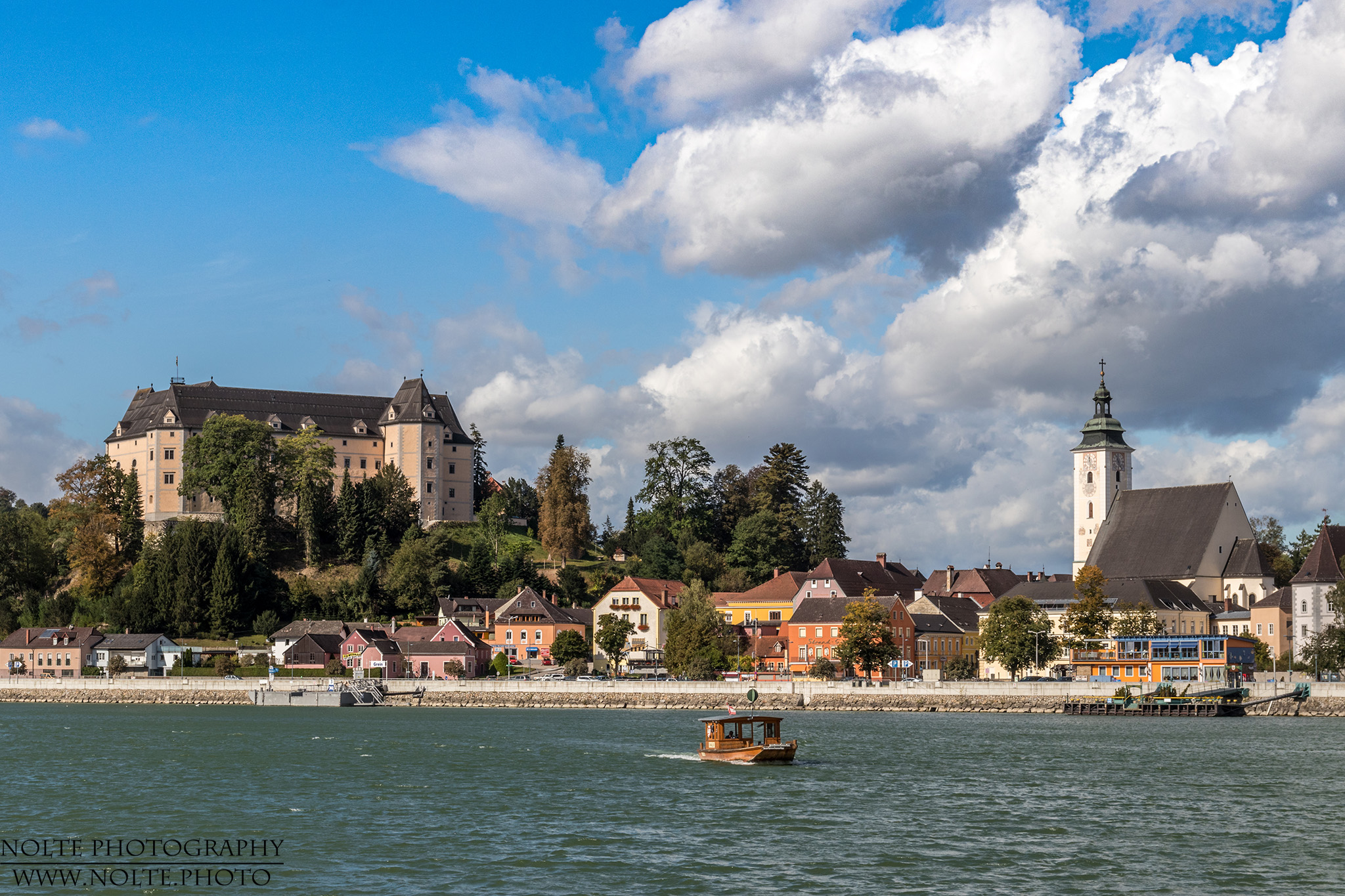 Blick über die Donau nach Grein mit Schloss Greinburg und Kirche.
